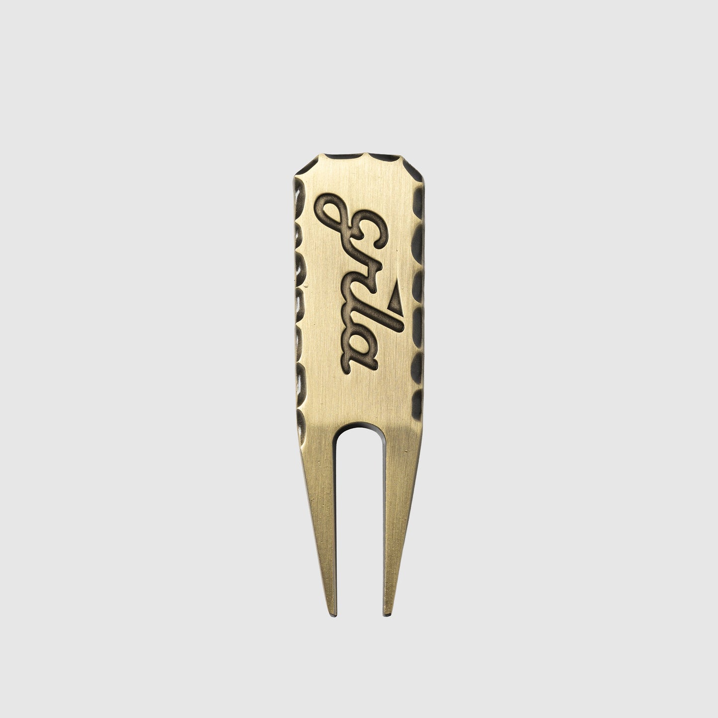 The Guerrilla Golf GRLA Raw Divot Tool, crafted from brass and engraved with "Spla," showcases textured edges and the official GRLA logo. Presented against a plain light gray background, this accessory embodies elegance for every golf enthusiast.