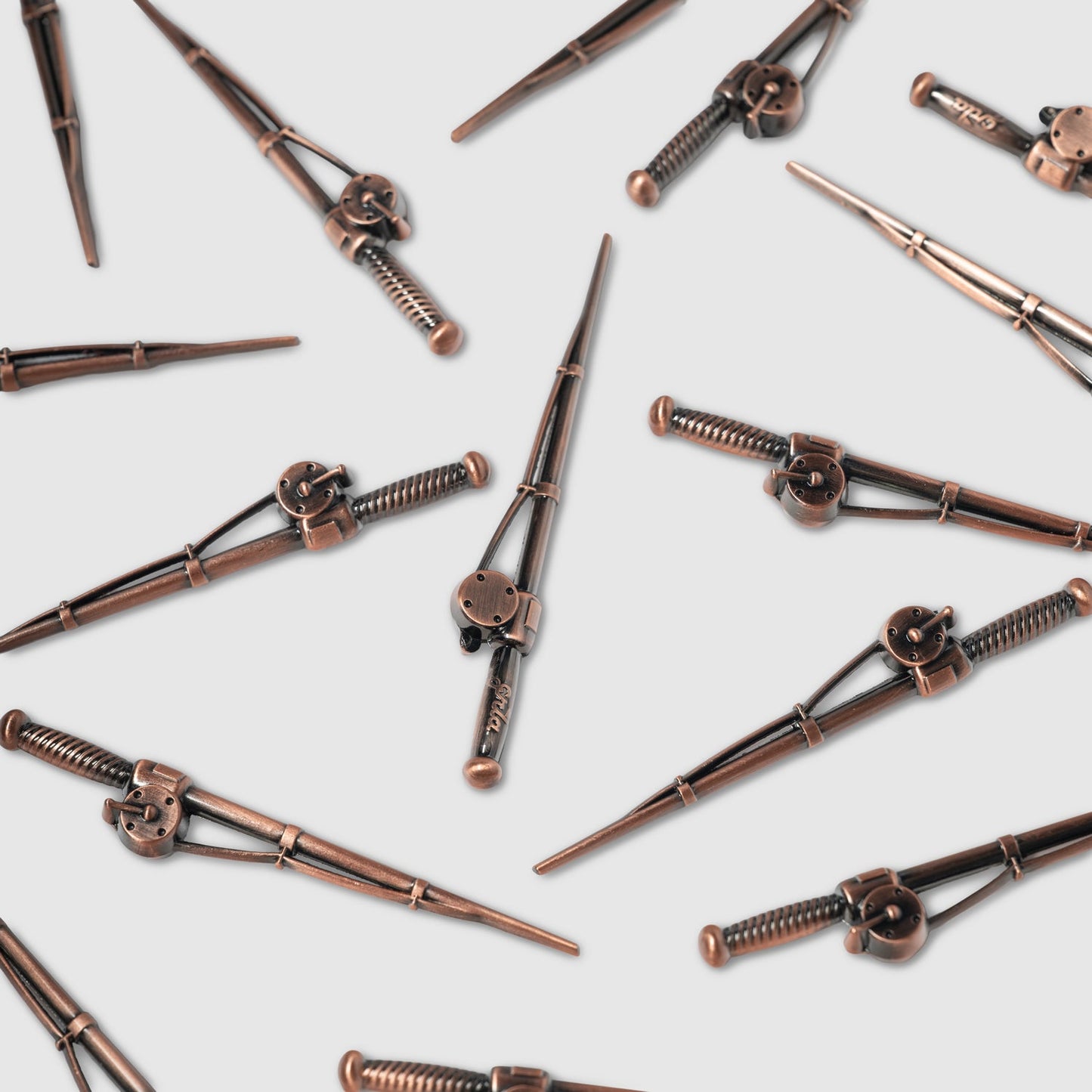 Several bronze-colored hair clips with intricate, steampunk-style designs—reminiscent of unique golf accessories like the Guerrilla Golf Fishing Pole Divot Tool—are scattered on a light gray background.
