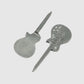 Two metal tools from Guerrilla Golf, shaped like electric guitars—one flat and one engraved with detailed guitar accents—are displayed on a simple grey background, highlighting the distinctive Guitar Divot Tool set.