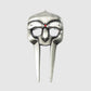 The Gladiator Divot Tool by Guerrilla Golf features a metallic mask design with a striking silver finish, two eye holes, a central red gem above the nose area, and two elongated vertical sections extending downward—resembling a sleek golf accessory for repairing divots on the green—prominently displayed against a plain gray background.