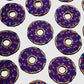 Evenly spaced across a white background, the design features circular blue Donut Ball Markers by Guerrilla Golf, each accented with red dots and gold outlines. With a central hole reminiscent of stylized wheels or decorated disks, these markers are arranged in a consistent pattern.