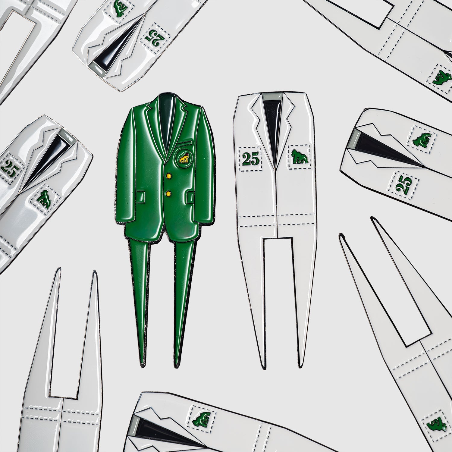 A green Caddy divot tool by Guerrilla Golf, shaped like a jacket and the perfect golf accessory or gift, is surrounded by white jacket-shaped Caddy divot tools adorned with golf-themed patches and numbers, all displayed on a white background.