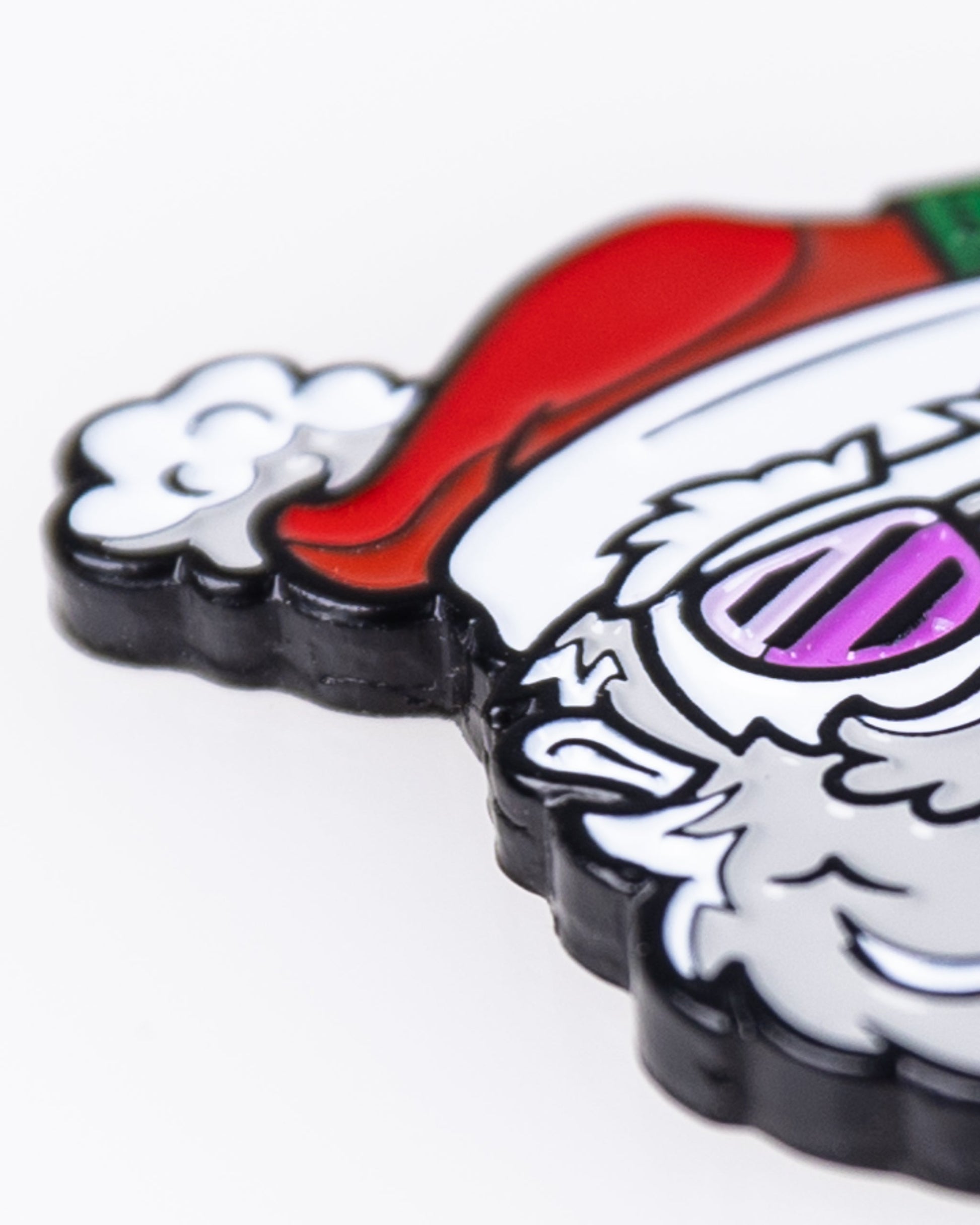 A close-up of the Pins and Aces Santa the Degenerate Ball Marker features a colorful, cartoon Santa design with his red hat, white beard, and a purple detail—perfect as a festive Christmas golf accessory.