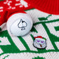 The Pins and Aces "Santa the Degenerate Ball Marker" features a magnetic Santa golf ball marker, Santa hat, and sunglasses-wearing Santa pin—ideal Christmas golf accessories on a festive red, white, and green sweater.