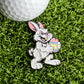 The Evil Bunny Ball Marker by Ballmarkers.com features a playful white bunny with an Easter egg, displayed on green turf beside a golf ball—a perfect Easter gift and fun golf accessory for any enthusiast.