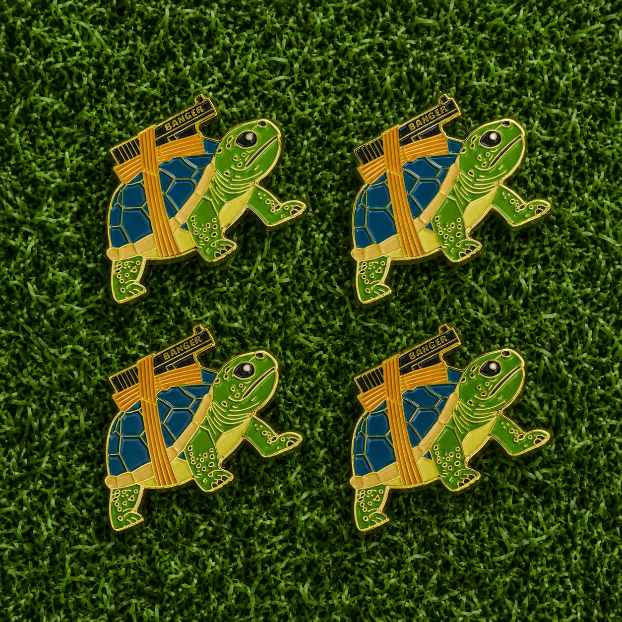 The Strapped Turtle Ball Marker Bundle from Ballmarkers.com features four turtle-shaped enamel ball markers with DANGER tape, arranged in a grid on green grass.