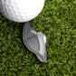 A close-up of a golf ball on artificial green grass with the Flip-Flop Sandal Ball Marker from Ballmarkers.com—an eye-catching golf accessory—displayed next to it on the putting green.