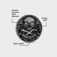 The Omen Classic Antique, Diamond & Silver Edition by Doubloon is a round sterling silver golf ball marker with a skull featuring lab-grown diamond eyes, black Cerakote crossbones, “MARKS THE SPOT” text, and a decorative border. Labels show each feature.