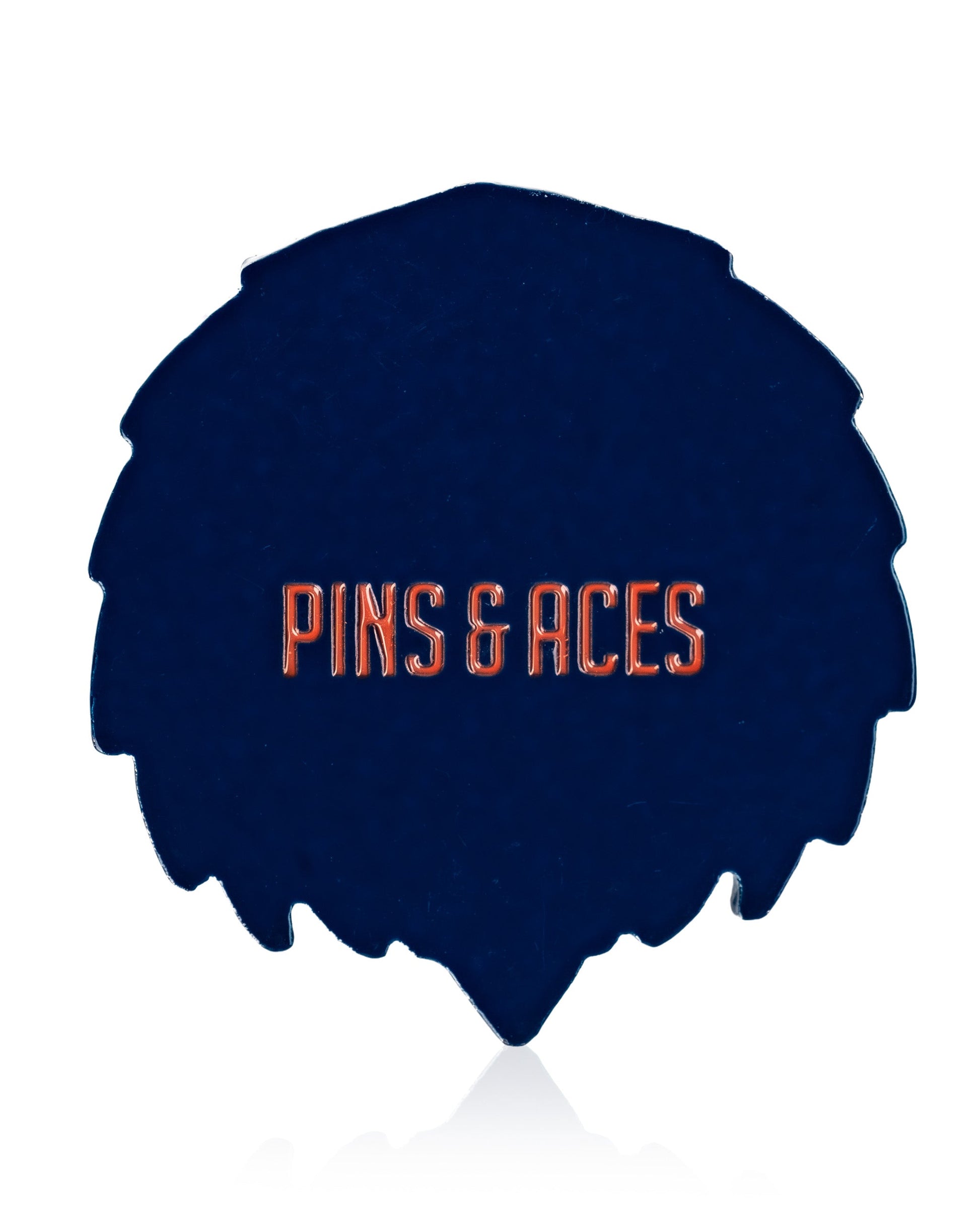 A dark blue, leaf-shaped Independence Eagle ball marker by Pins and Aces with bold orange branding—a perfect patriotic accessory to add flair to your Fourth of July golf game.
