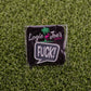 The F*ck! Speech Bubble pin by Logie Joe's Golf features a playful design on branded packaging with a palm tree and flamingo logo, displayed on green turf—ideal for fans of funny golf accessories or unique ball markers.
