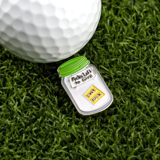 The Jar of “F”s Ball Marker from Logie Joe's Golf is a hilarious premium accessory—a golf ball rests by green grass and a pin shaped like a jar labeled Fucks Left to Give, holding just one last "F." Perfect for fans of funny golf gear.