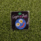 The Breakfast Ball pin by Logie Joe's Golf, shaped like a golf ball with fried egg eyes and a bacon mouth, comes on grass with branded card—making it an ideal premium ball marker.