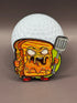 The Gill Cheese Ball Marker by Crown Golf Designs features a cartoonishly angry grilled cheese character with a metal spatula, standing before a giant golf ball, with melted cheese dripping and a fierce look.