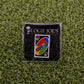 The Gimme Wild Card by Ballmarkers from Logie Joes, a premium UNO-inspired ball marker with GIMME, is showcased on artificial green grass and attached to a branded LOGIE JOES card.
