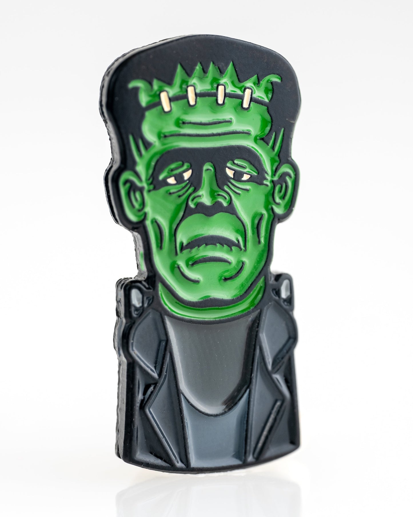 The Frankenstein Ball Marker by Pins and Aces is a premium, colorful enamel golf accessory featuring a stylized bust of Frankenstein’s monster with green skin, black hair, and a dark jacket on a white background.