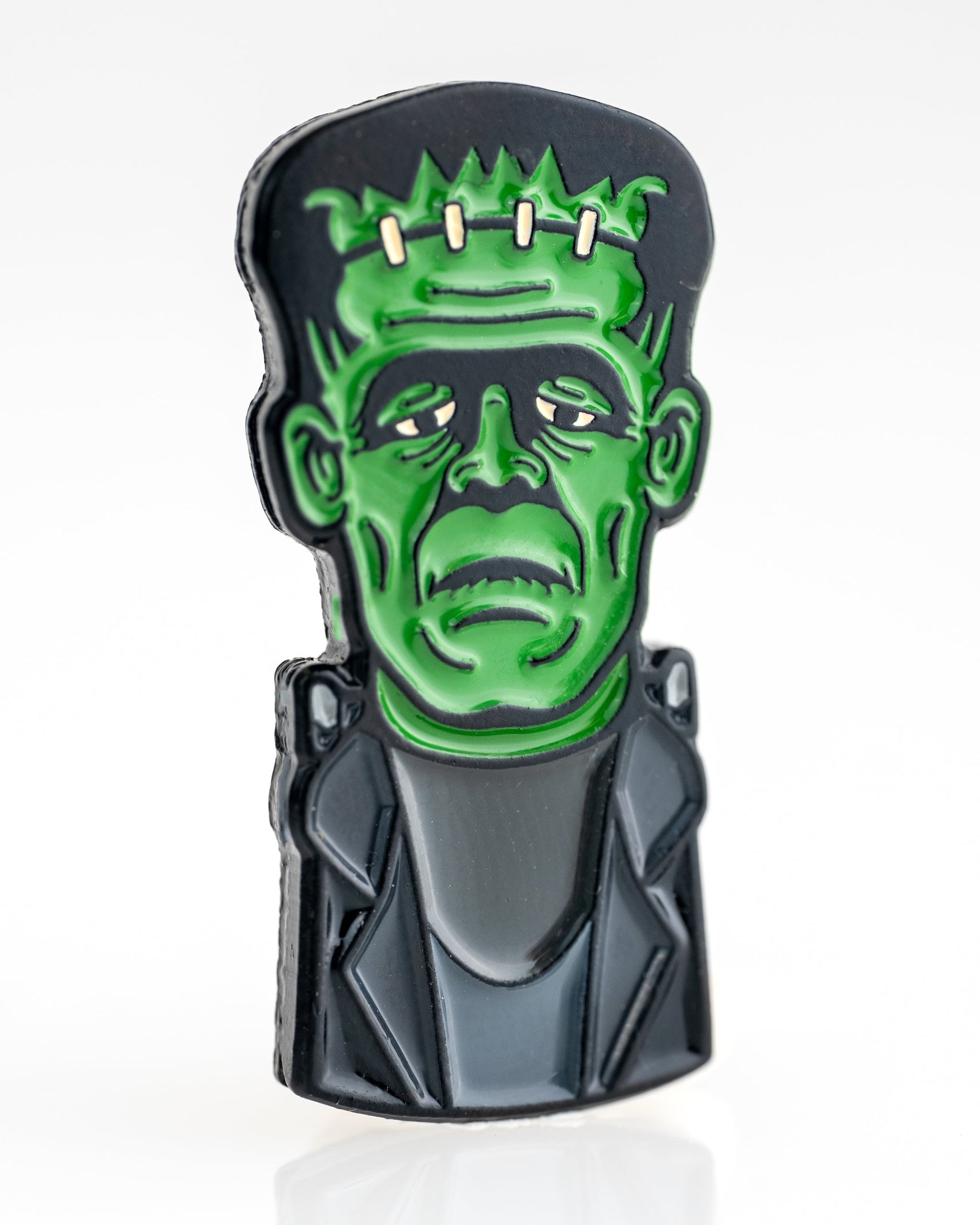 The Frankenstein Ball Marker by Pins and Aces is a premium, colorful enamel golf accessory featuring a stylized bust of Frankenstein’s monster with green skin, black hair, and a dark jacket on a white background.