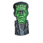 The Pins and Aces Frankenstein Ball Marker is a premium golf accessory shaped like Frankenstein’s monster, featuring a green face, black hair, stitches on the forehead, and a gray suit. Displayed isolated on white with a soft shadow.