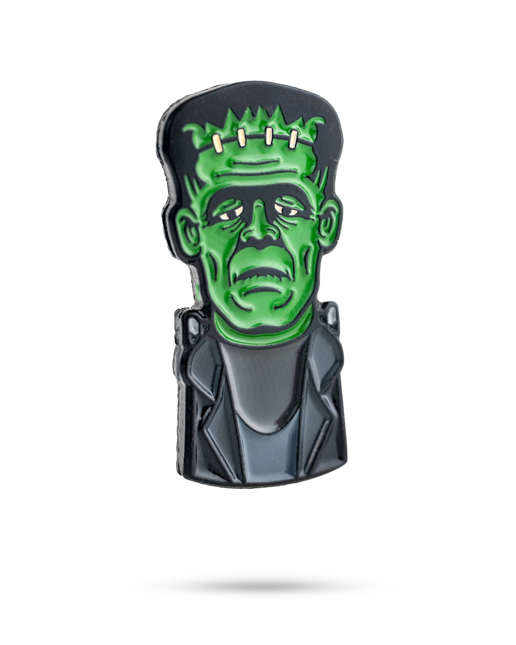 The Pins and Aces Frankenstein Ball Marker is a premium golf accessory shaped like Frankenstein’s monster, featuring a green face, black hair, stitches on the forehead, and a gray suit. Displayed isolated on white with a soft shadow.