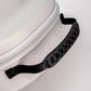 A close-up of the Pins and Aces Hat Caddie, a white golf hat case featuring a textured black handle and black strap, set against a plain white background.