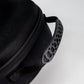 Close-up of the Pins and Aces Hat Caddie, a black zippered golf hat case featuring a textured plastic handle and fabric strap, shown against a plain white background.