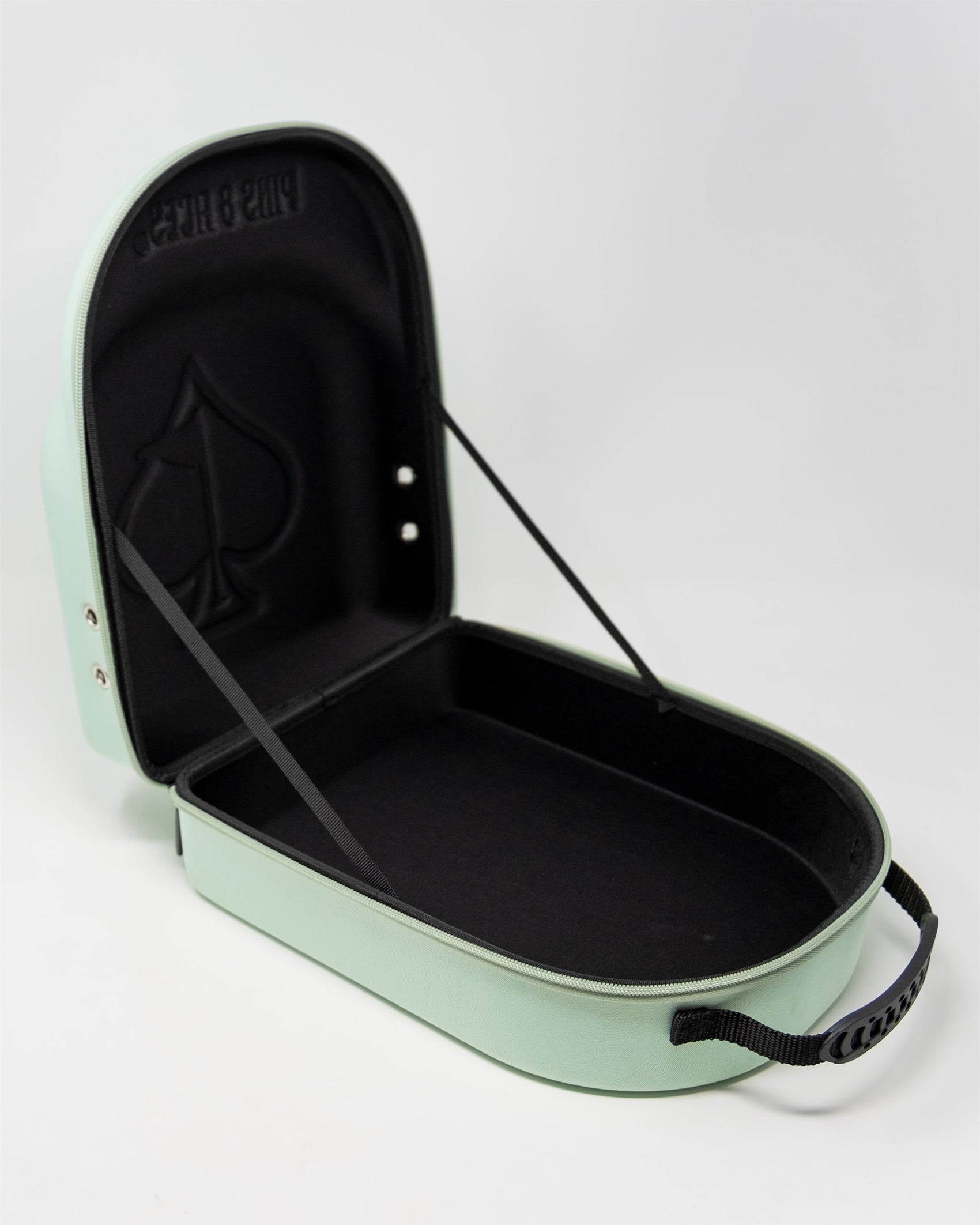 The Pins and Aces Hat Caddie, in light green, opens to reveal a black interior with an embossed spade symbol and elastic lid straps. Featuring a black handle and silver hardware, it keeps your hats secure and stylish on the go.