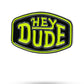 The HEYDUDE - Logo Ball Marker by Pins and Aces features a cast metal design with a black background, neon green border, and bold neon green "HEY DUDE" lettering—an iconic addition to the Pins and Aces ball markers collection.