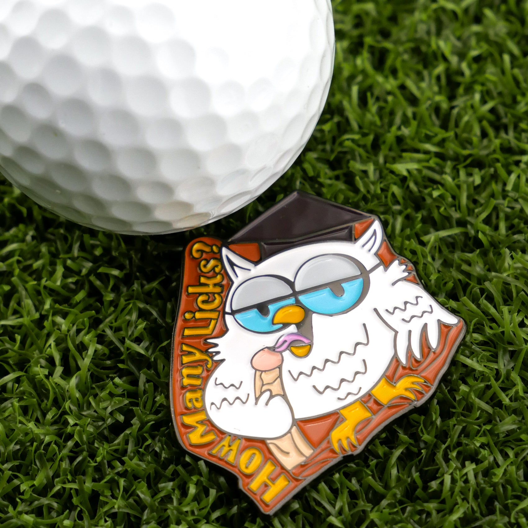 The "How many licks? Owl" golf ball marker from Ballmarkers.com features a cartoon owl in glasses and grad cap licking a lollipop, next to the text “How Many Licks?”—a perfect funny accessory for golfers.