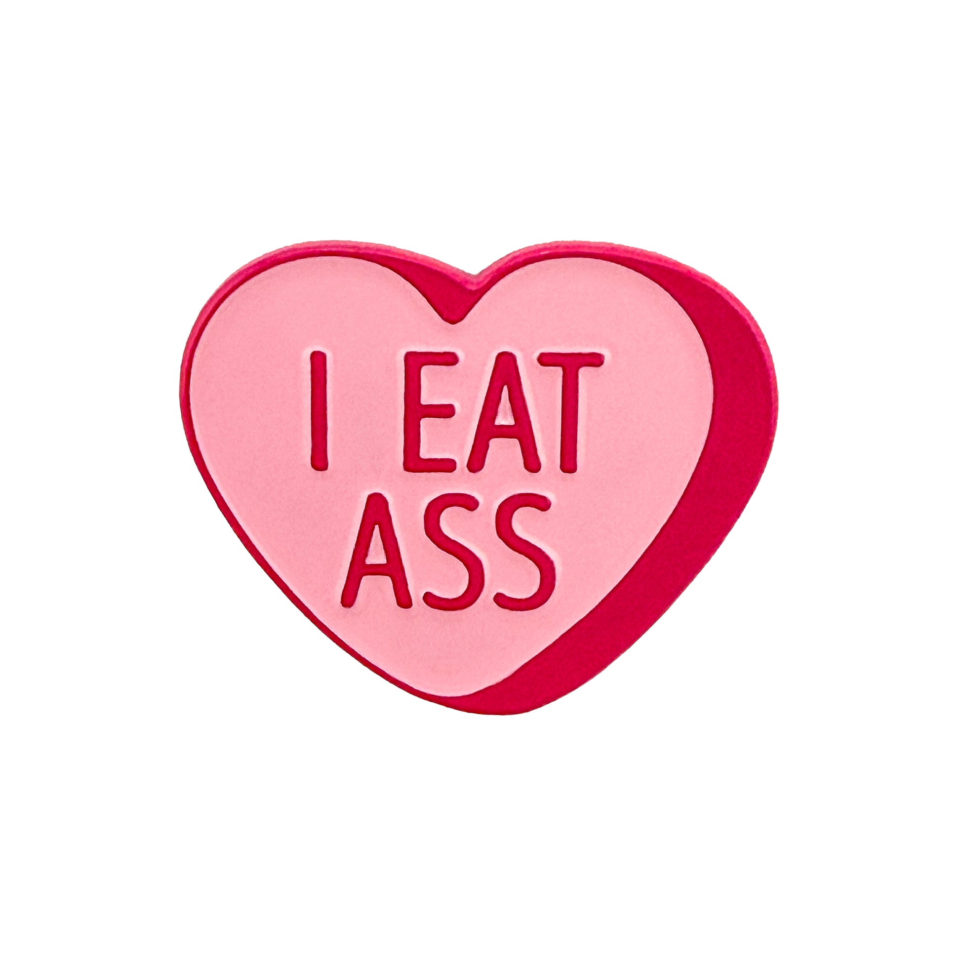 The Logie Joe's Golf I Eat A** Candy Heart Ball Marker is a pink, heart-shaped marker featuring "I EAT ASS" in bold red letters.