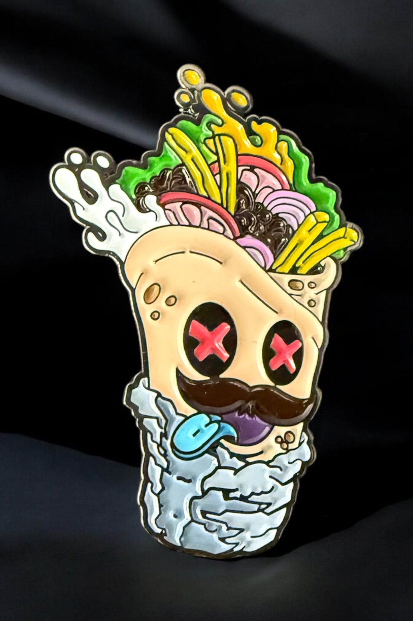 The Burrito Ball Marker by Crown Golf Designs features a cartoon burrito wrap with pink X eyes, mustache, blue tongue, fries and veggie fillings, playful expression, and magnetic hot sauce on a dark background.
