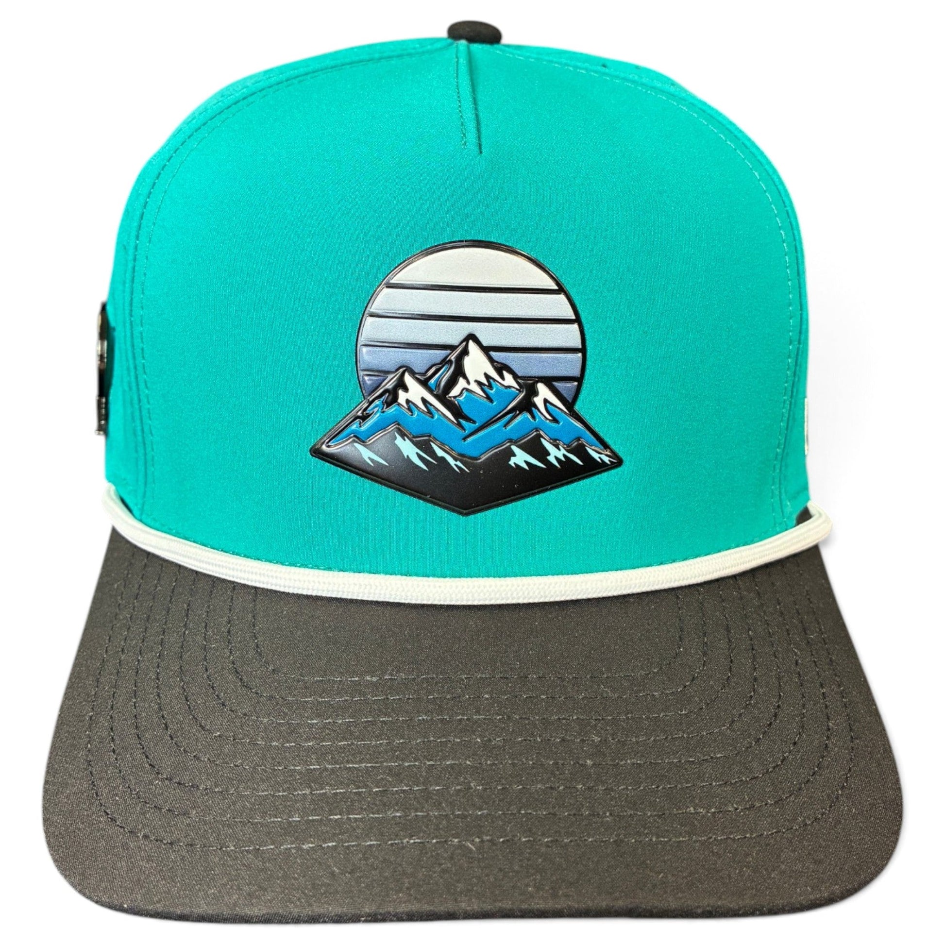 Introducing the Mountain Moonrise Golf Hat by Logie Joe’s Golf—a turquoise and gray snapback cap featuring a mountain and sun graphic on the front panel. This outdoor golf hat offers white trim above the brim, a flat dark gray bill, and an adjustable snapback for comfort. Plus, it includes a built-in magnetic ball marker holder with marker included, making it perfect for any adventure on or off the course.