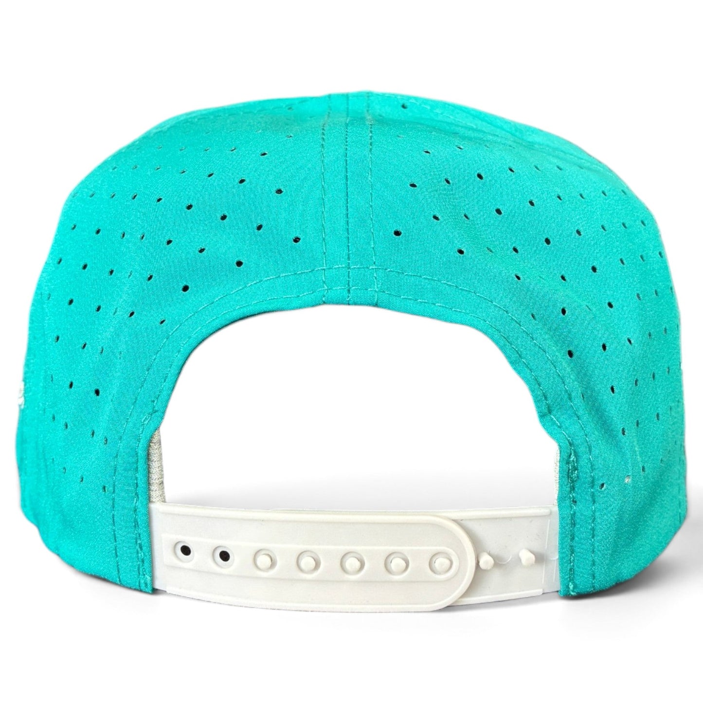 Introducing the Logie Joe’s Golf Mountain Moonrise Golf Hat: a teal snapback cap viewed from the back, featuring ventilation holes for breathability and an adjustable white plastic strap for a customized fit. This outdoor-inspired hat combines sporty style and practical comfort, with the added convenience of a built-in magnetic ball marker holder plus marker included—perfect for your next round on the golf course.
