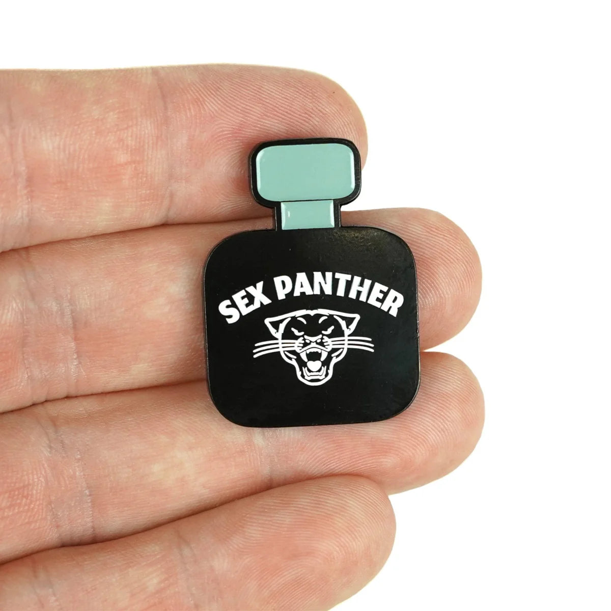 A hand holds a small pin by Bogey Bros shaped like a black perfume bottle labeled "Sex Panther," featuring a roaring panther head and the phrase "works every time" beneath.