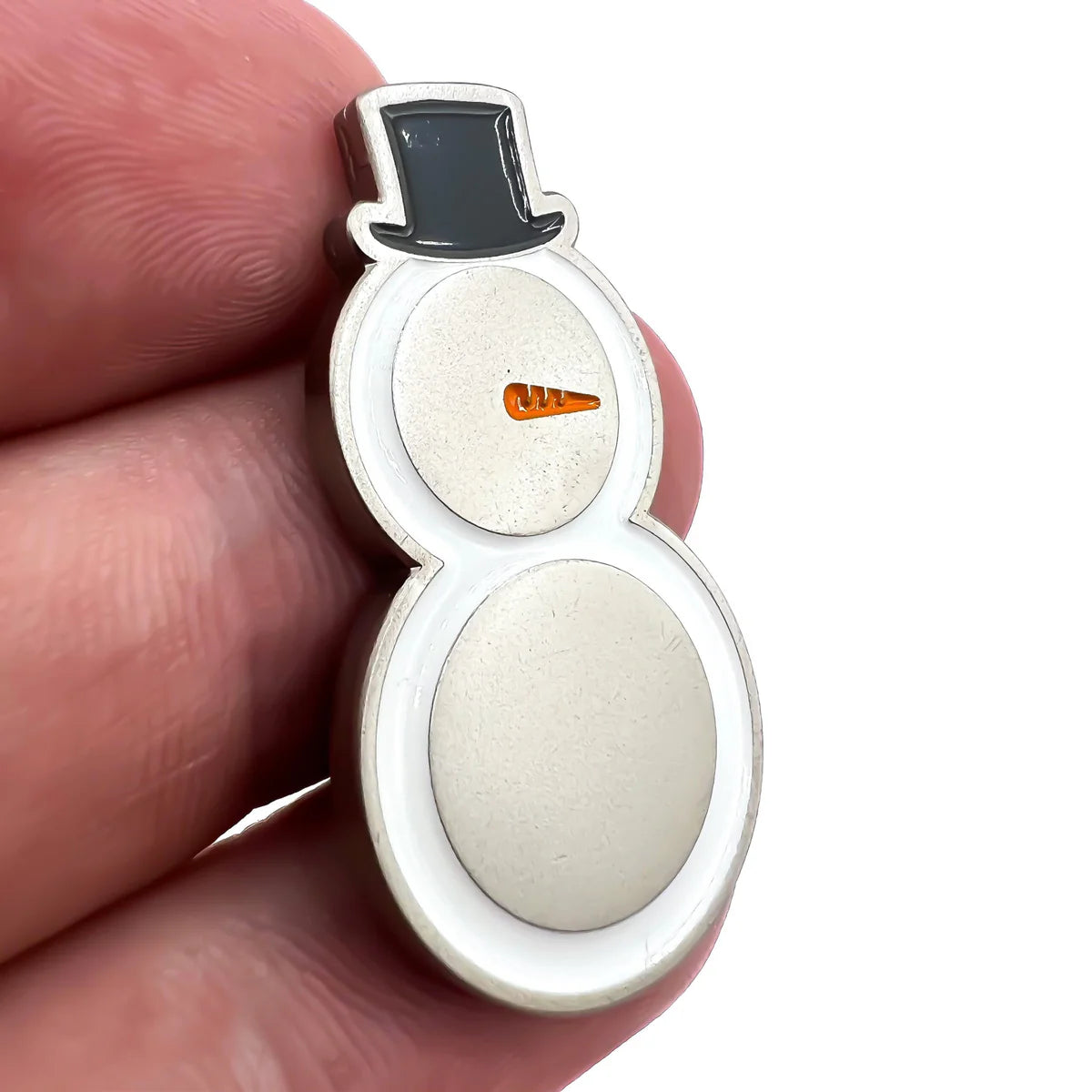 A hand holds the Bogey Bros "Snowman" pin featuring a snowman with a black top hat and an orange Nike swoosh for a nose—ideal for Snowman golf fans or anyone who loves unique, humorous golf accessories.
