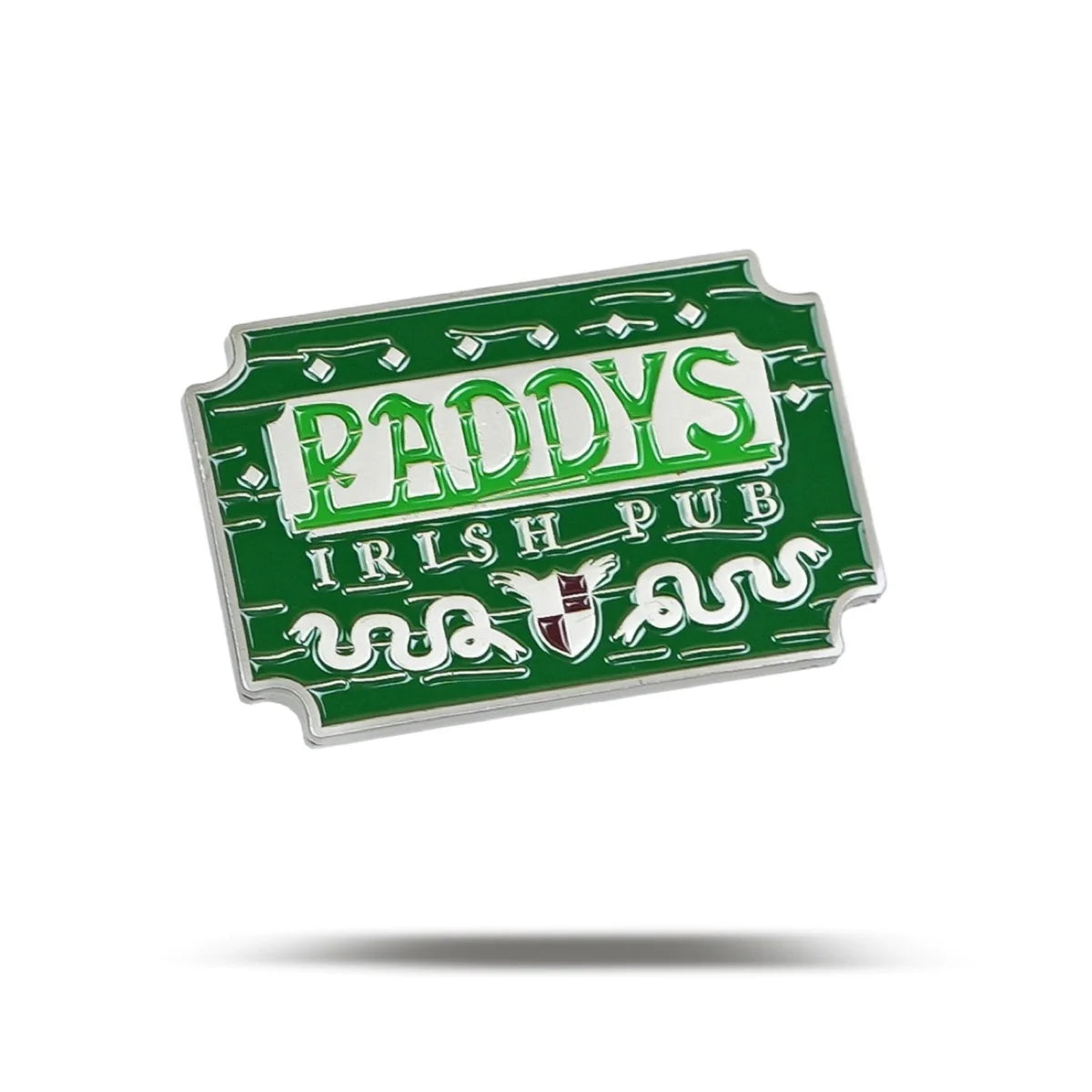 A green sign with white and light green text reading “Paddy's Pub” by Bogey Bros, featuring decorative accents and a central shield, resembles a stylish golf ball marker with a shadow beneath.