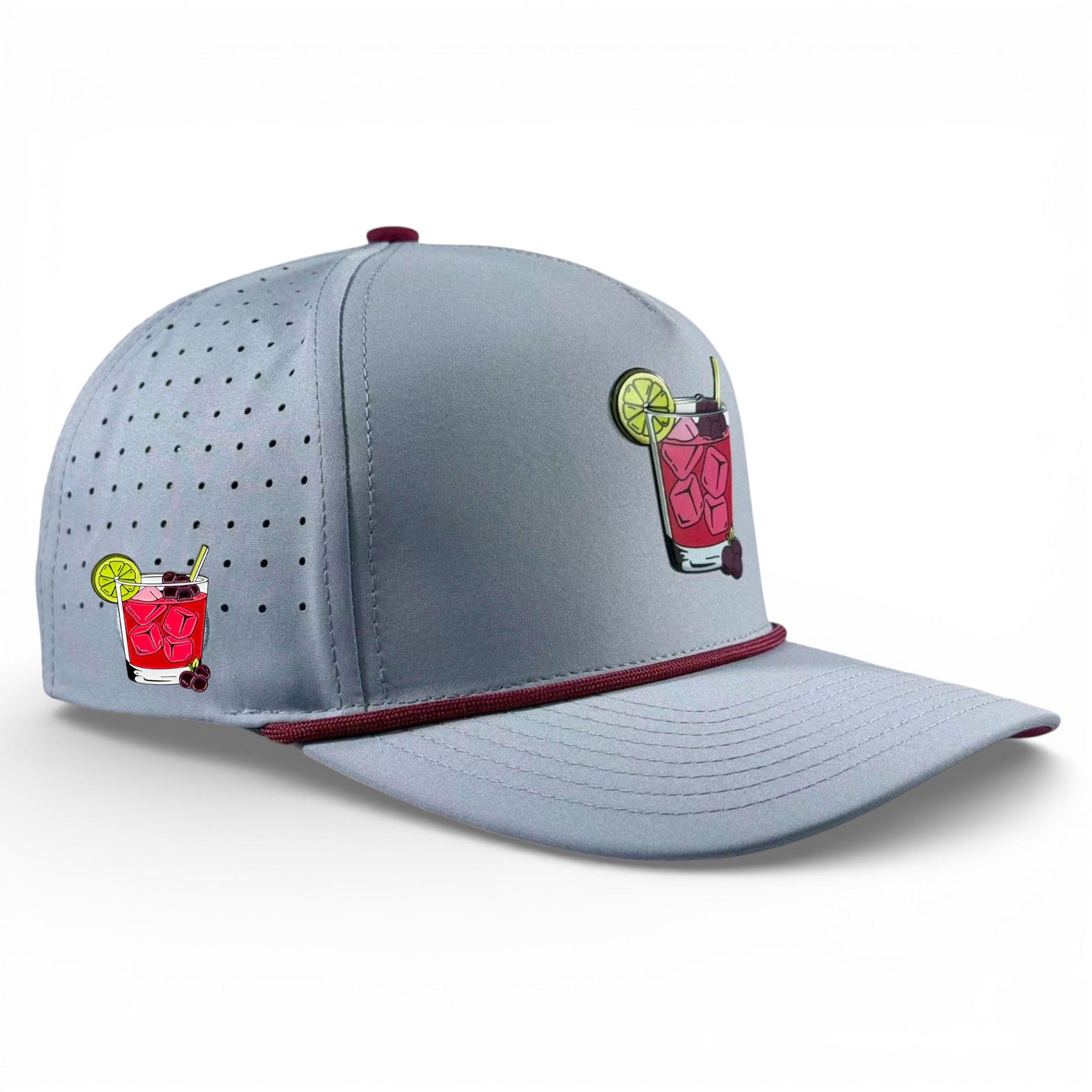 The Logie Joe's Golf Transfusion Golf Hat is a light gray snapback cap with burgundy piping, an embroidered cocktail glass design, built-in magnetic ball marker holder with marker, adjustable fit, and side ventilation holes.