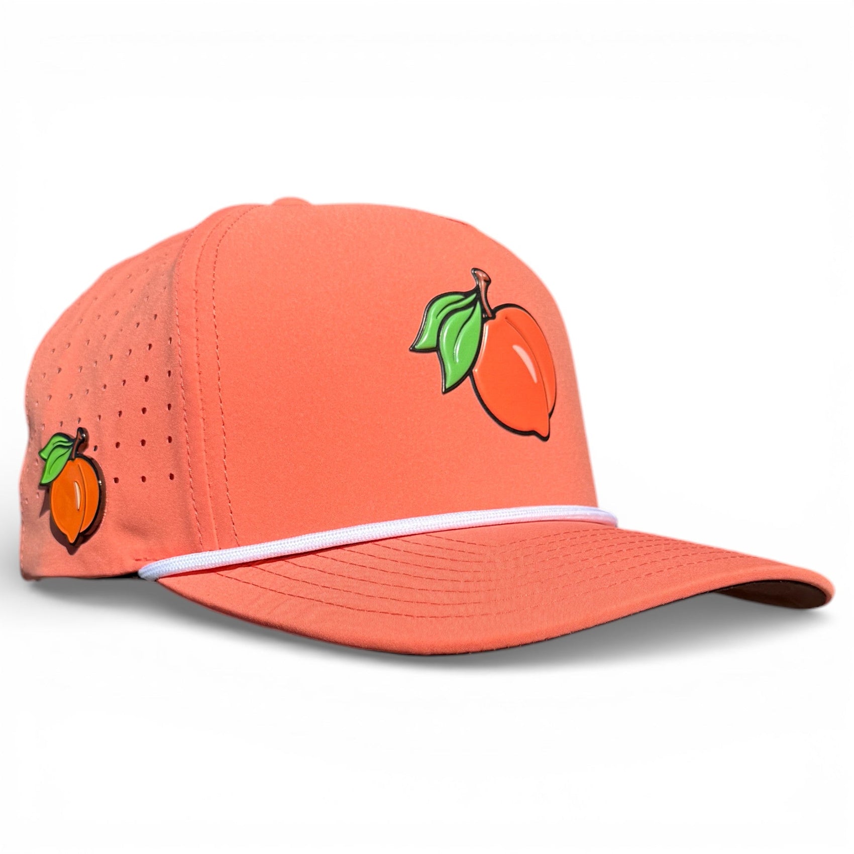 Logie Joe's Golf Just Peachy Golf Hat: coral snapback cap with a peach fruit graphic, perforated for ventilation, white band, adjustable fit, and built-in magnetic ball marker holder (marker included).