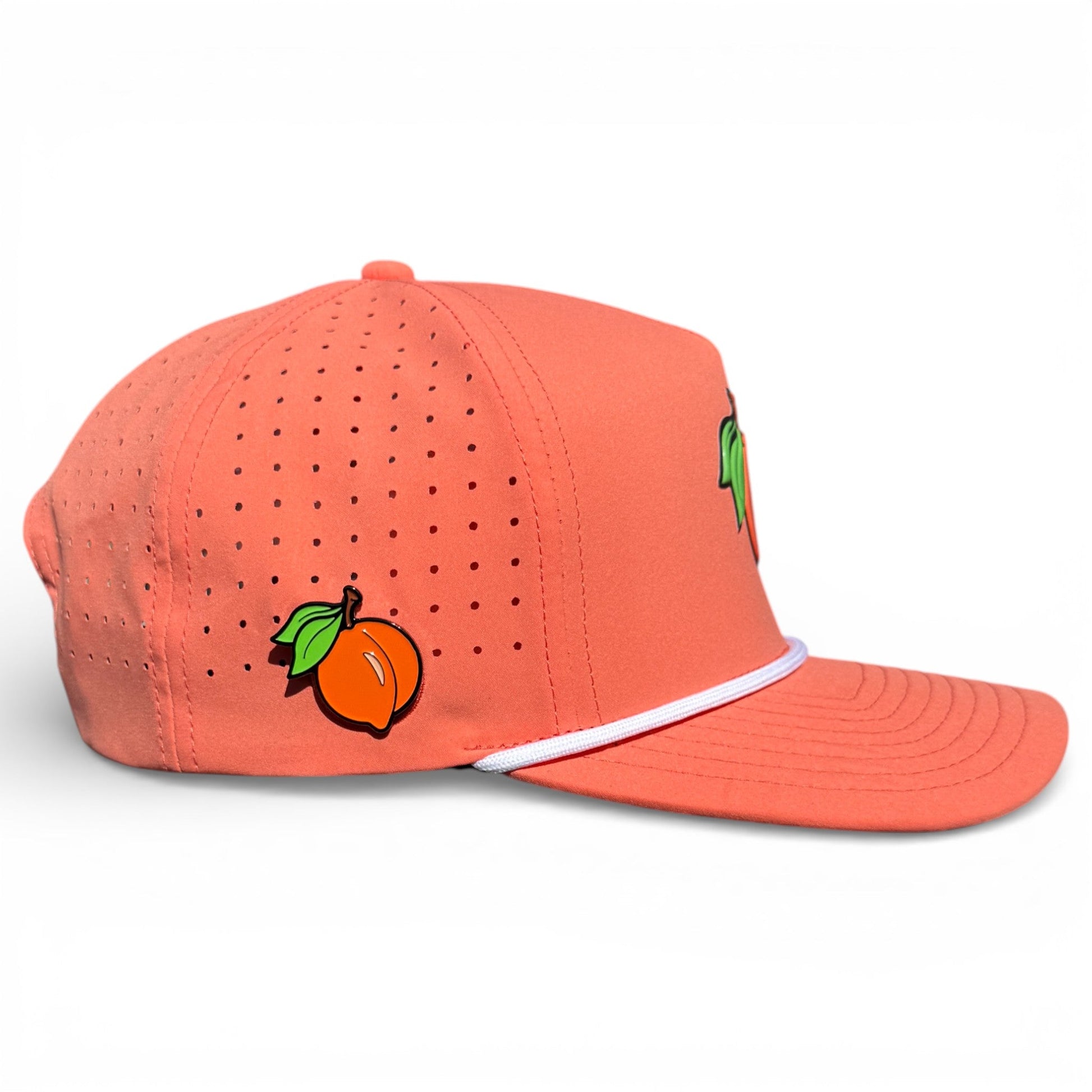 The Just Peachy Golf Hat by Logie Joe's Golf is a coral snapback cap featuring perforated sides, a peach graphic, white accent line, and an adjustable fit—plus a built-in magnetic ball marker holder with marker included for added function.