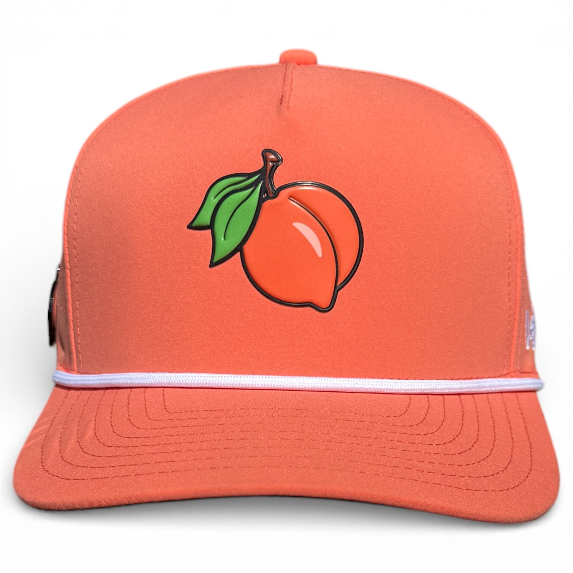 The Just Peachy Golf Hat by Logie Joe's Golf is an adjustable orange snapback cap with a peach and green leaves embroidery, white stripe detail, and built-in magnetic ball marker holder with marker included.