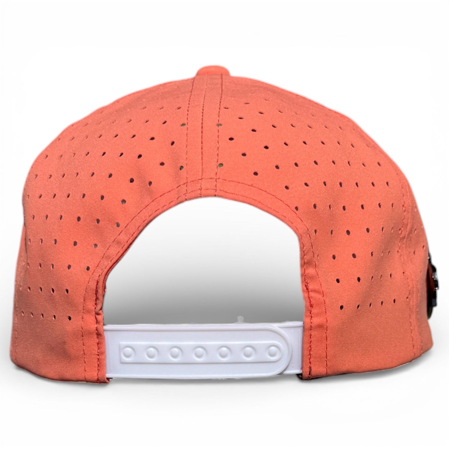 The Just Peachy Golf Hat by Logie Joe's Golf is a stylish peach snapback cap with small ventilation holes, an adjustable white plastic closure, and a built-in magnetic ball marker holder plus marker—perfect for sunny golf days.
