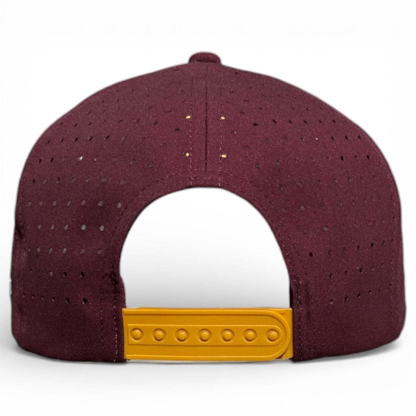The image shows the back of a maroon Logie Joe's Golf Cold One Snapback Cap, featuring small perforated holes, a yellow adjustable strap, and a built-in magnetic ball marker holder. The background is white.
