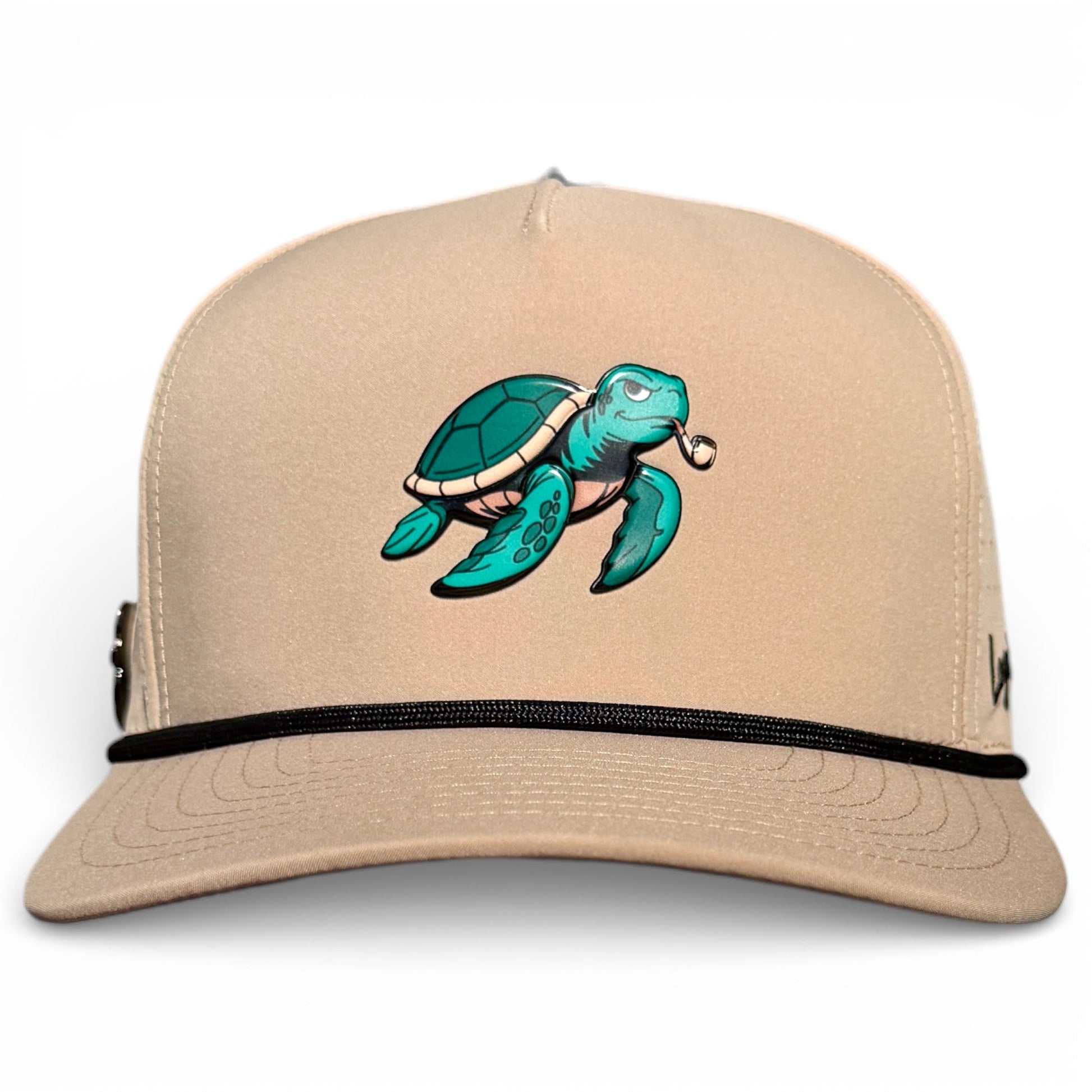The Salty Turtle Golf Hat by Logie Joe's Golf is a beige snapback featuring a cartoon sea turtle with a pipe, black rope detail, and built-in magnetic ball marker holder—adjustable to fit all and includes marker.