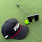 The Logie Joe's Golf Free Golf Balls Van Snapback Hat with matching neon green ball marker sits beside a black putter on green turf.