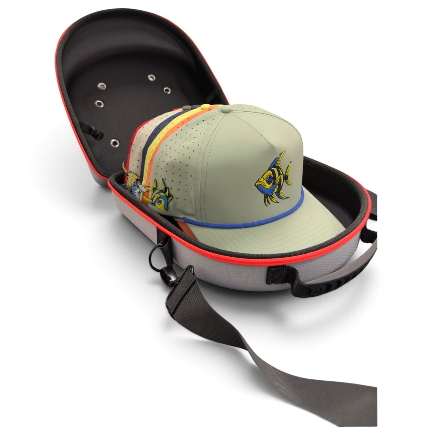 Four pastel-colored caps with fish logos are neatly stacked inside the Logie Joe’s Golf Hat Caddy Travel Case—a gray and red hard shell carrier that holds up to six hats. The protective hat storage case, equipped with an adjustable shoulder strap, is shown open on a white background.