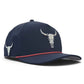 Introducing the Logie Joe’s Golf Outlaw Golf Hat—a navy blue snapback cap featuring a bold bull skull logo on both the front and side, striking red trim on the brim, and perforated holes for ventilation. This stylish hat comes equipped with a built-in magnetic ball marker holder (marker included) and an adjustable snapback design, delivering all-day comfort and functionality both on and off the course.