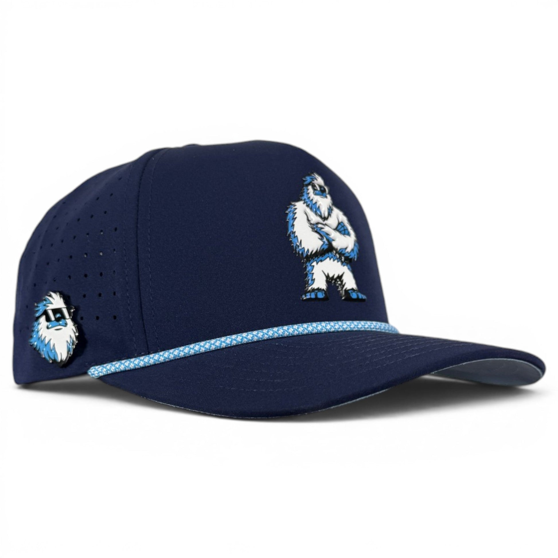 Introducing the Zero Chill Yeti Golf Hat by Logie Joe’s Golf—a navy snapback cap featuring a white and blue abominable snowman graphic on the front, a smaller yeti head on the side, blue patterned rope across the brim, and perforated sides for breathability. With an adjustable fit, built-in magnetic ball marker holder (plus marker included), this golf hat is designed for all-day comfort both on and off the course.
