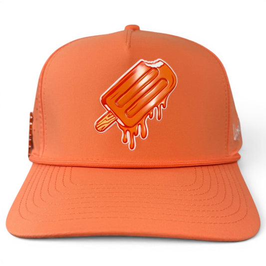 The Logie Joe’s Golf Orange Dream Golf Hat is an adjustable snapback cap featuring a playful graphic of a melting orange popsicle with a bite taken out of it on the front panel. This stylish orange baseball cap also includes a built-in magnetic ball marker holder and comes with a marker.
