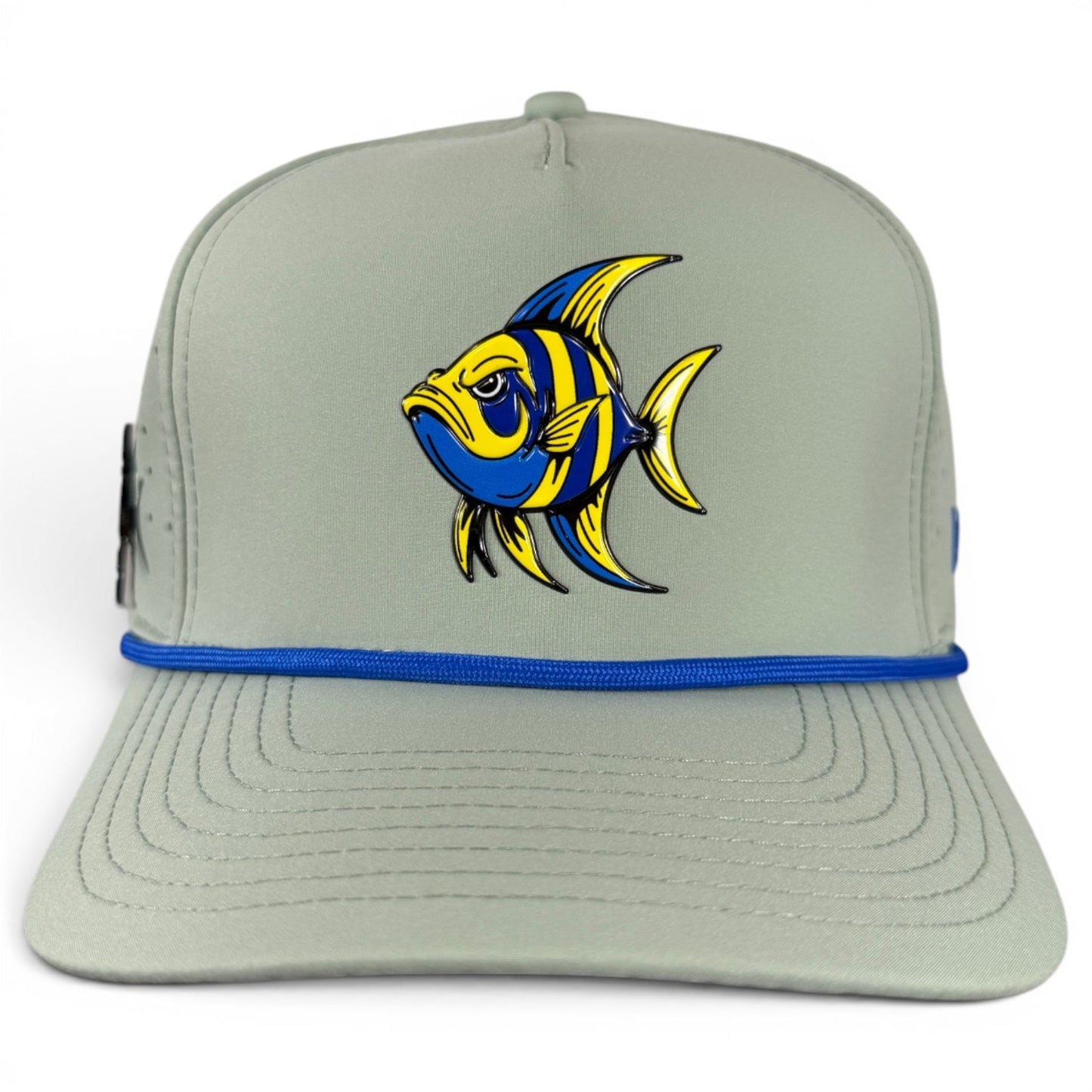 Introducing the Angelfish Golf Hat from Logie Joe’s Golf—a light gray snapback cap featuring a vibrant blue and yellow angelfish illustration on the front and a stylish blue accent band above the brim. Designed for comfort with an adjustable fit, this hat also offers a built-in magnetic ball marker holder (marker included), making it a practical choice for golf enthusiasts.