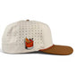 Introducing the Old Fashioned Golf Hat by Logie Joe’s Golf—a cream-colored, adjustable snapback cap designed with small ventilation holes and a brown brim. This stylish golf hat features an enamel pin depicting a cocktail garnished with an orange slice and cherry on the side, plus a built-in magnetic ball marker holder with included marker for added convenience on the course.