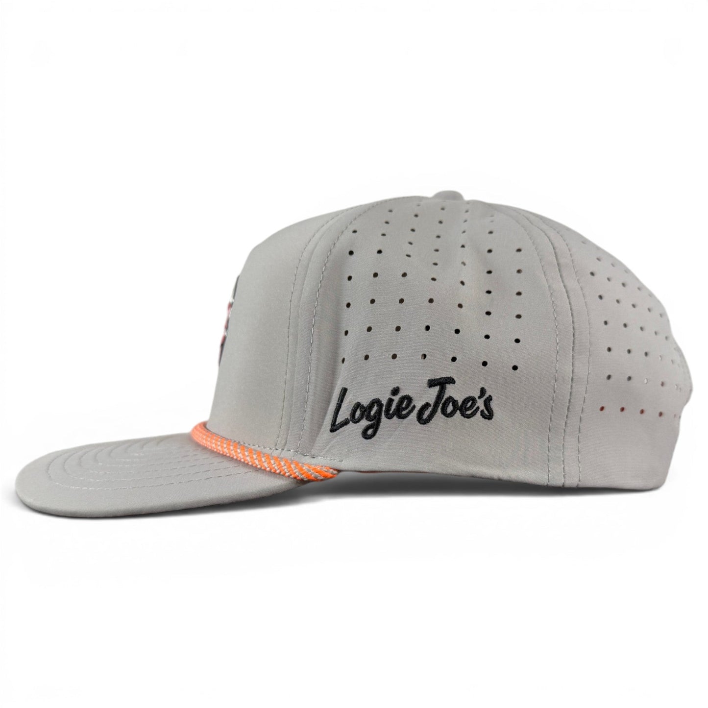 A sleek light gray snapback cap by Logie Joe’s Golf, the Fossil Fairway Golf Hat features small ventilation holes, orange and white accents on the brim, and “Logie Joe’s” embroidered in black on the side. Designed for golfers who appreciate both style and practicality, it comes with an adjustable fit and a built-in magnetic ball marker holder with marker included.