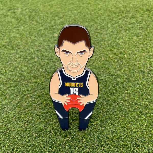 Joker by Pin Creatures is a small cartoon-style pin, perfect as a golf ball marker, showing a basketball player in a navy Nuggets #15 jersey holding a ball and standing on green grass.